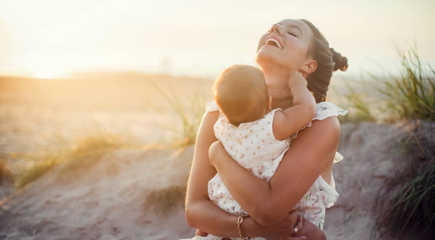 Frau mit Baby am Strand