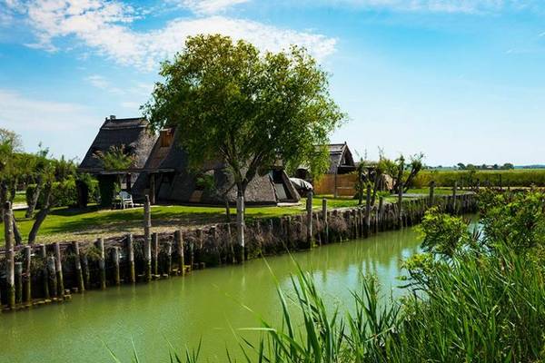 Luftaufnahme eines Wasserparks mit roter Rutsche und umgebender Infrastruktur.