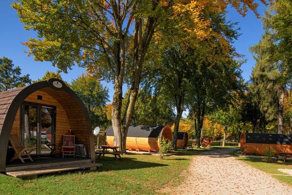 Camping au bord du lac avec camping-cars et mobil-homes, montagnes en arrière-plan