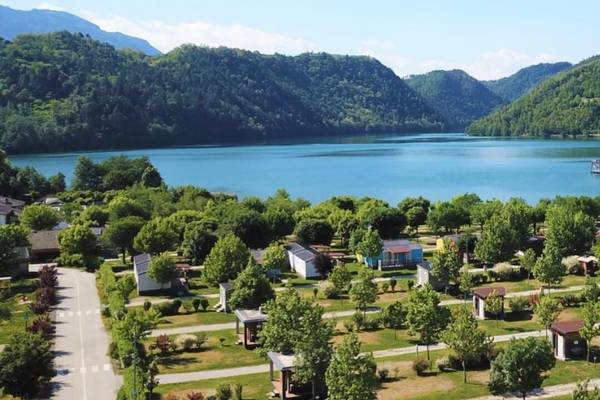 Luftaufnahme von Lago Levico Camping Village mit einem See und Bergen im Hintergrund.