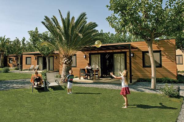 Luftaufnahme vom Playa Montroig Camping Resort mit Gebäuden, Swimmingpool und grüner Landschaft.