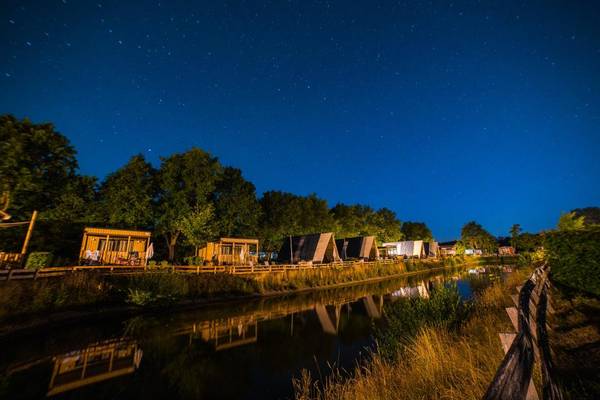 Luftaufnahme eines Campingplatzes mit Spielplatz und umliegenden Gebäuden.
