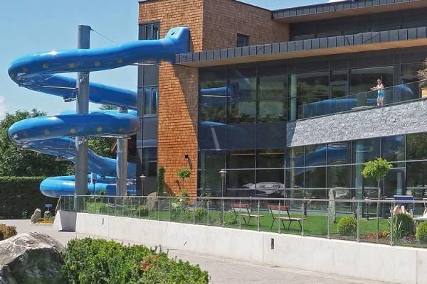 Nachtansicht des Sportcamps Woferlgut mit beleuchtetem Außenpool und Wasserrutsche.