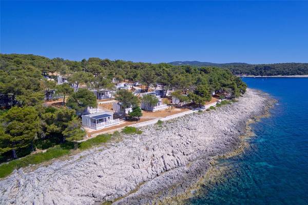 Campingplatz am Wasser Luftaufnahme eines Campingplatzes am Meer mit weißen Hütten und blauem Wasser