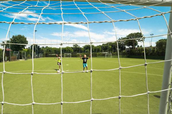 A pool at Piani di Clodia campsite with a waterfall and people swimming