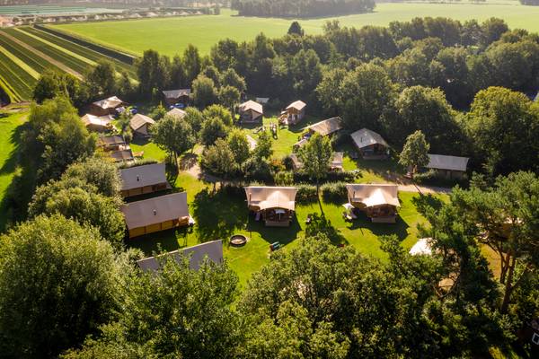 Luftaufnahme eines Campingplatzes mit Spielplatz und umliegenden Gebäuden.