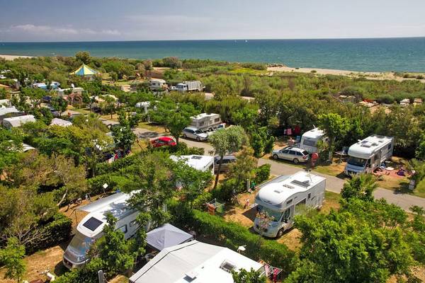 Luftaufnahme von Camping Village Le Brasilia mit Strand, Hafen und Resort-Einrichtungen.
