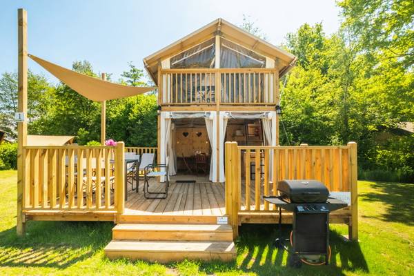 Cabina a due piani nel Campeggio Papillon Country Resort con balcone, barbecue e zona pranzo all'aperto.