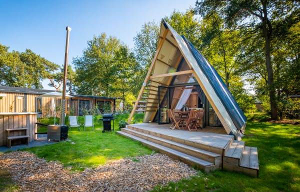 Lodge moderna nel Campeggio Papillon Country Resort con terrazza in legno e posti a sedere all'aperto.