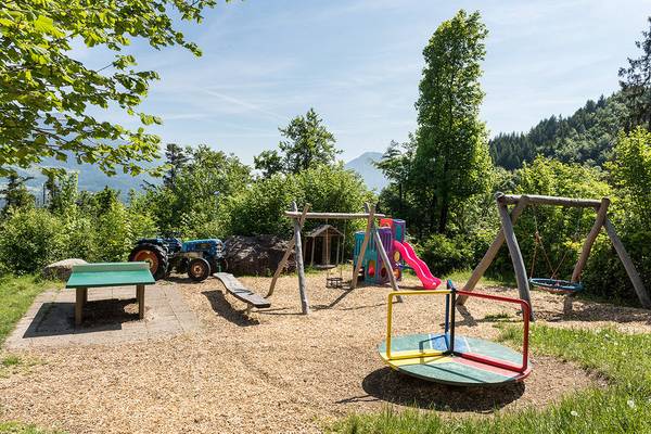 Área de juegos para niños en el camping de las Alpes Nenzing con diversos equipos de juego.