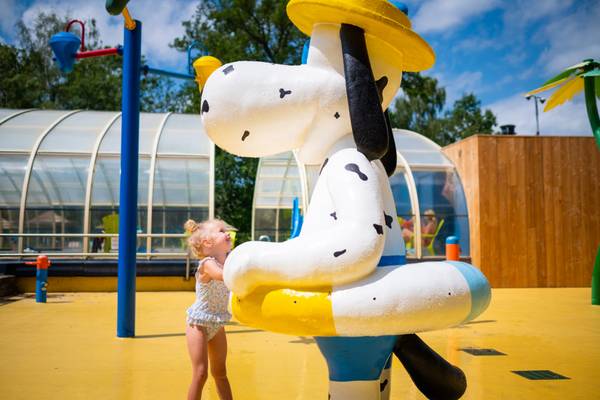 Bambina che gioca con la statua di Snoopy nel campeggio