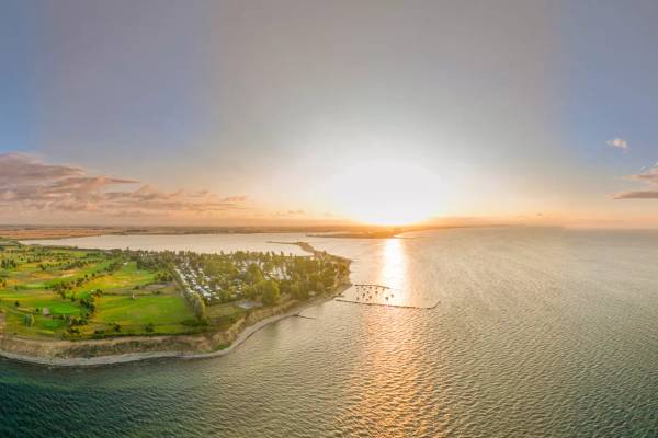 Sonnenuntergang über dem Campingplatz Wulfener Hals mit Blick auf Meer und Golfplatz.