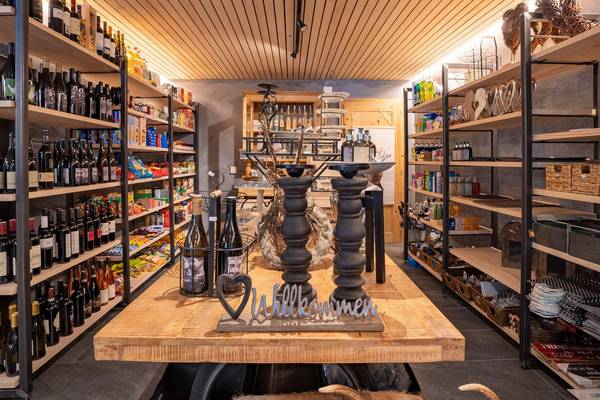 Tienda de comestibles en Alpencamping Nenzing con estanterías llenas de botellas y productos.