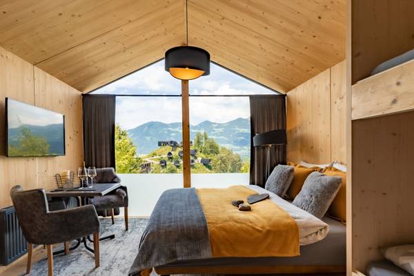 Interior del Alpencamping Nenzing mostrando una habitación con una gran ventana con vista a las montañas.