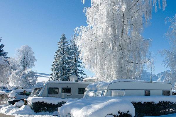 Camping met besneeuwde campers en bomen in de winter.