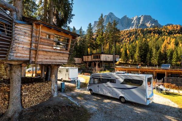 Campeggio Caravan Park Sexten con camper davanti alla casa sull'albero
