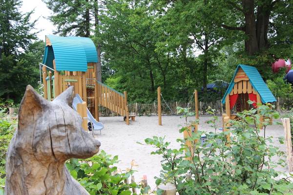 Speeltuin op Camping De Wildhoeve met houten constructies en een glijbaan.