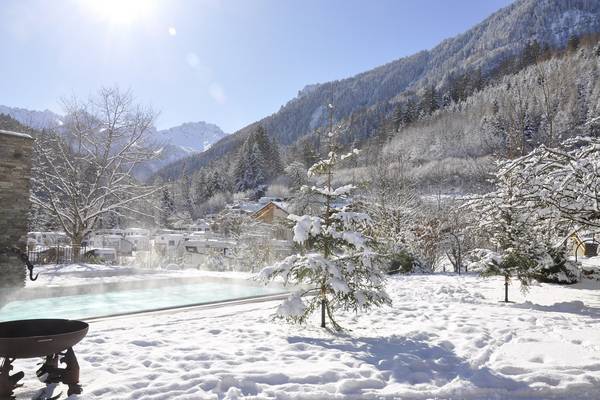 Escena invernal en el Alpencamping Nenzing con árboles cubiertos de nieve y una piscina