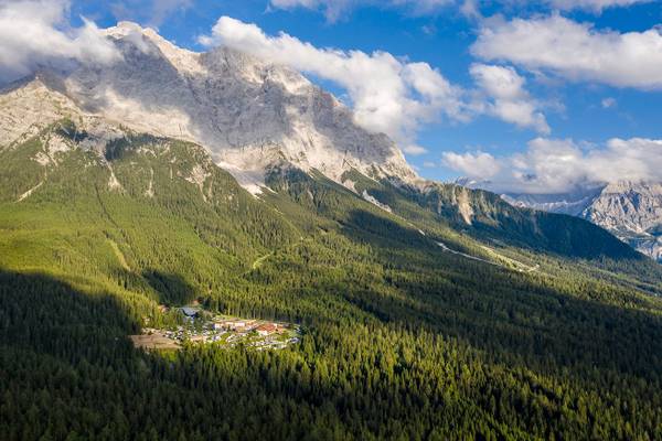 Luftaufnahme des Zugspitz Resort Campingplatzes mit Bergen und Wald