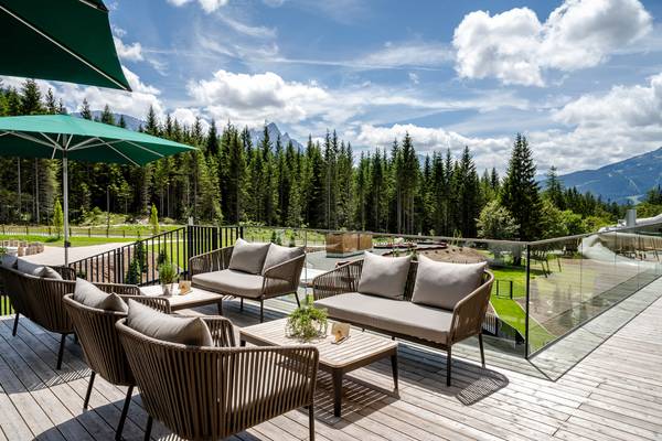 Terrasse mit Sofas und Sonnenschirm im Zugspitz Resort Campingplatz