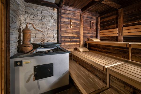 Zugspitz Resort Sauna mit Holzbänken, Ziegelwand und Dampferzeuger.