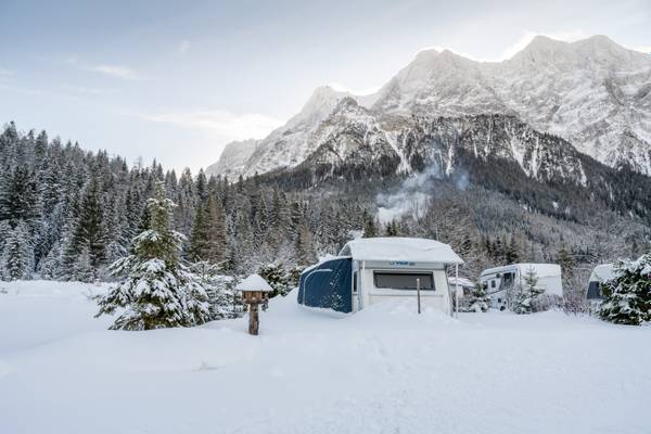 Campingplatz im Zugspitz Resort mit verschneiten Bergen im Hintergrund.