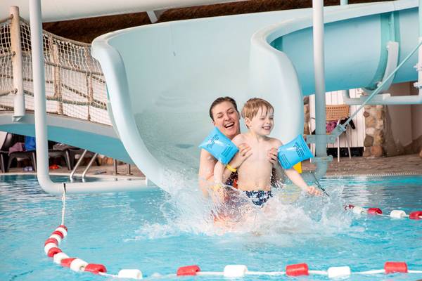 Frau und Junge im Schwimmbad mit einer Rutsche im Hvidbjerg Strand Feriepark.