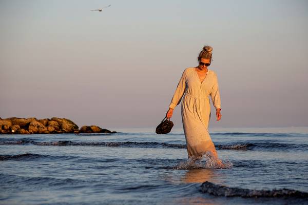 Frau, die im Wasser am Hvidbjerg Strand geht