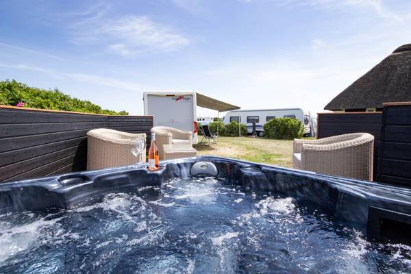 Jacuzzi auf dem Campingplatz Hvidbjerg Strand Feriepark mit zwei Gläsern Wein.