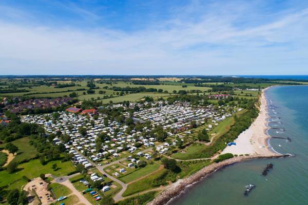 Luftaufnahme des Ostseecamping Heide Campingplatzes mit vielen Wohnwagen und Strand