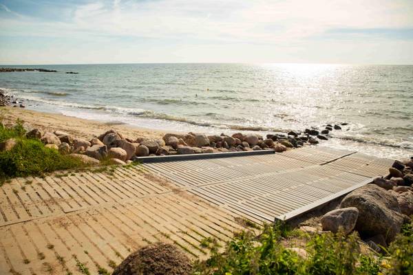 Strandzugang mit Steinen und Holz an der Ostseeküste