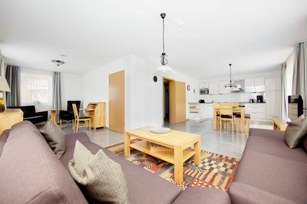 Innenbereich Wohnzimmer von Ostseecamping Heide mit Sofas, Couchtisch und Essbereich.
