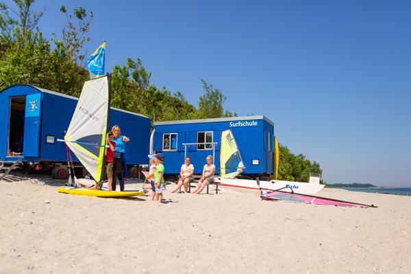 Surfschule und Campingplatz am Strand mit Familien und Kindern.