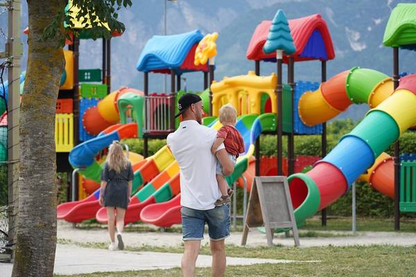 En familie nyder en dag på den farverige legeplads ved Lago Levico Camping Village.