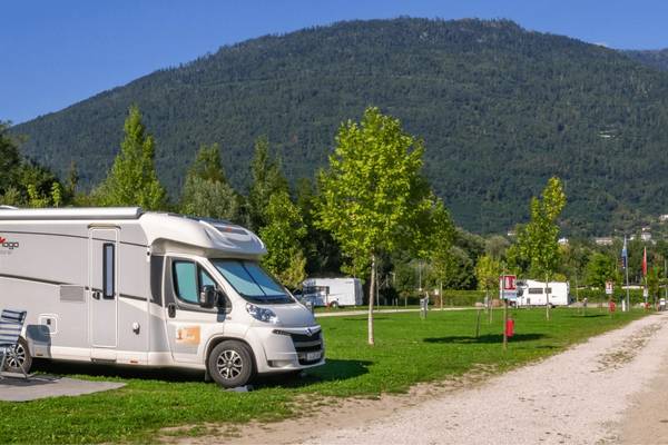 Campingplads med en autocamper og bjerge i baggrunden