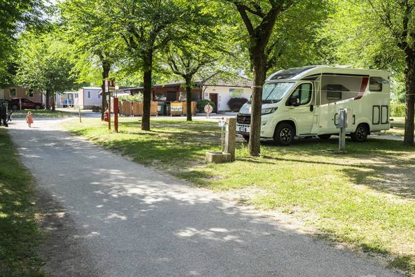 En campingvogn parkeret under træer i Lago Levico Camping Village