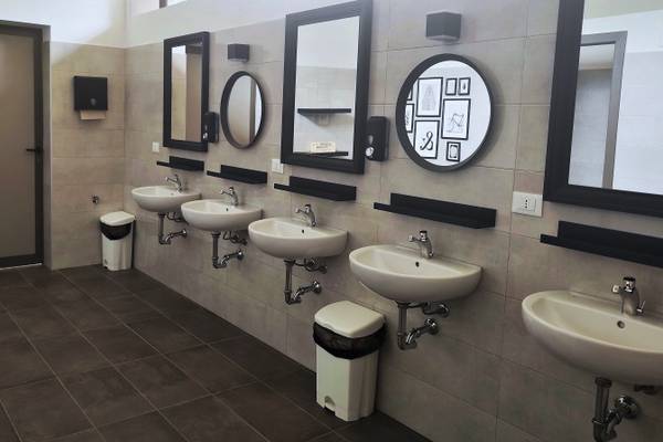 Salle de bain avec plusieurs lavabos et miroirs.