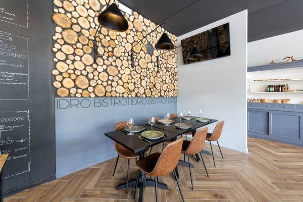 Espace repas au Lago Idro Glamping Boutique Campsite avec mur en rondins de bois et table noire.