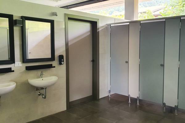 Zone de sanitaires du camping de glamping boutique avec lavabos et cabines.