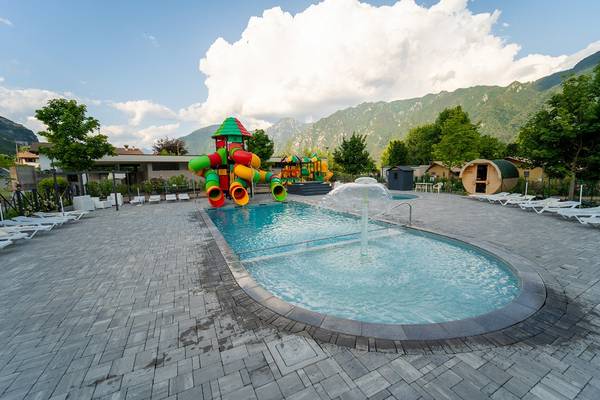 Espace piscine extérieure avec toboggan et vue sur la montagne au camping Lago Idro Glamping Boutique.