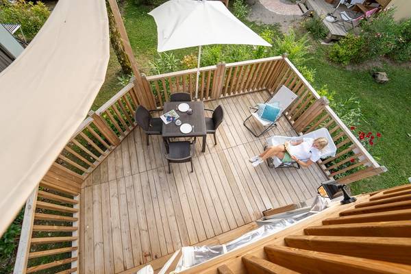 Terrasse supérieure avec table et chaises sous un parasol