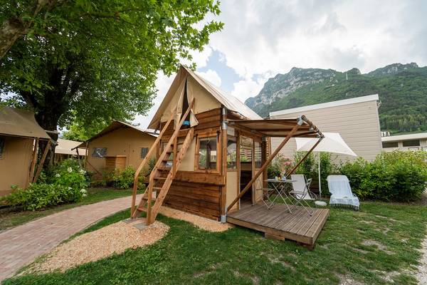 Tent de glamping boutique au camping Lago Idro avec montagnes en arrière-plan.