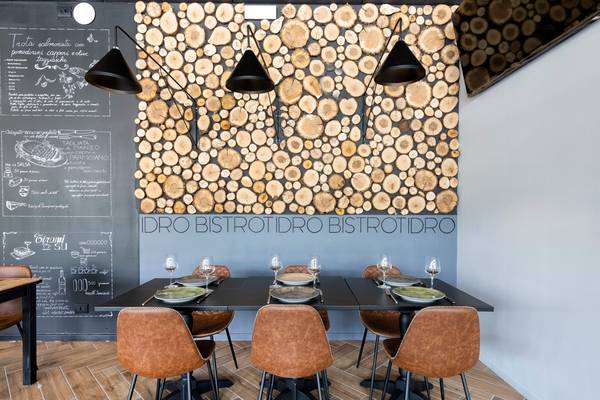 Vue intérieure d'un restaurant avec un mur en bois et des sièges.