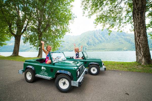 Deux filles dans un petit jeep devant le lac Idro