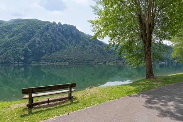 Un banc en bois au bord d'un lac avec des montagnes en arrière-plan