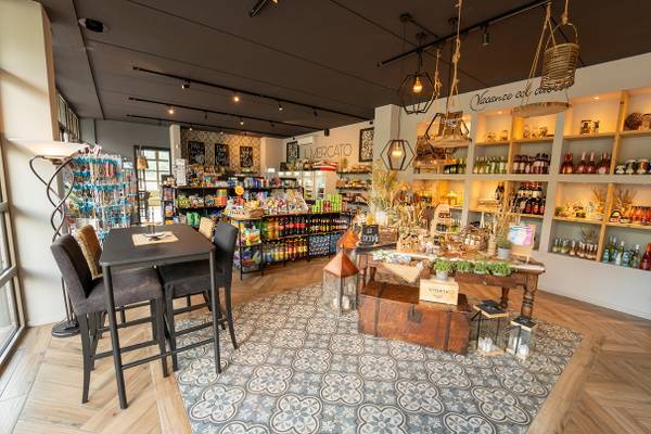 Intérieur d'un magasin de boutique au Camping Lago Idro Glamping avec tables, étagères et produits.