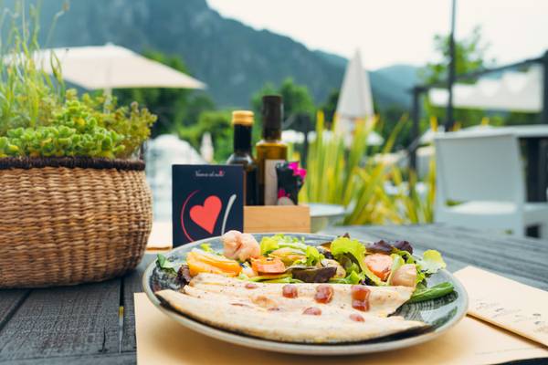 Une assiette de nourriture sur une table au camping Lago Idro Glamping Boutique avec vue sur les montagnes.