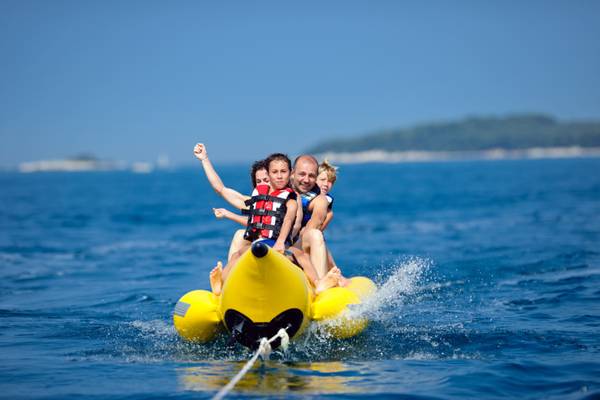 Famille profitant d'une balade en bateau banane sur l'océan au Camping Vestar.