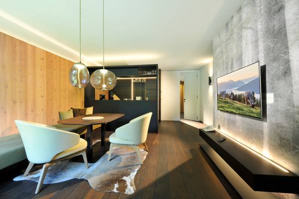 Inneneinrichtung des Ferienparadies Natterer See mit Tisch, Stühlen und montiertem Fernseher.