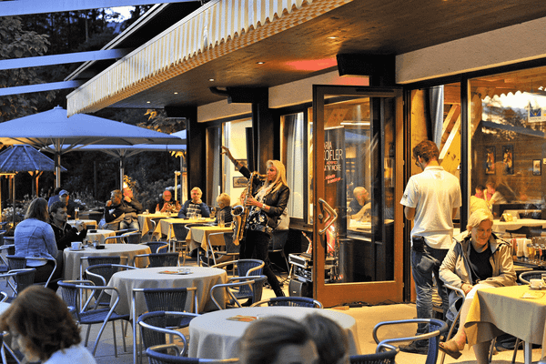 Saxophonspielerin auf der Terrasse des Ferienparadies Natterer See Campingplatz in Österreich.